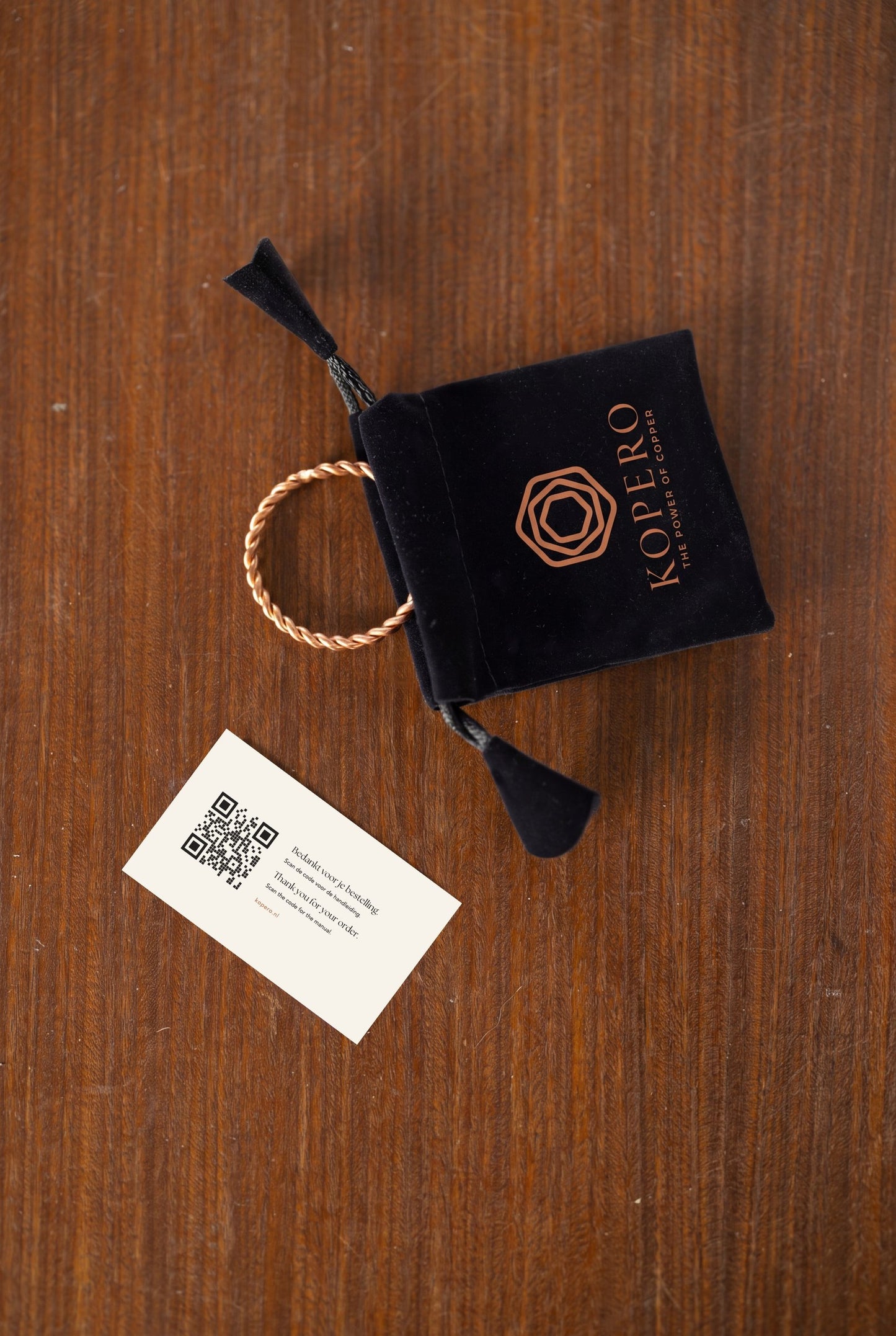Kopero Copper Tensor Ring next to the velvet pouch and the card with QR code