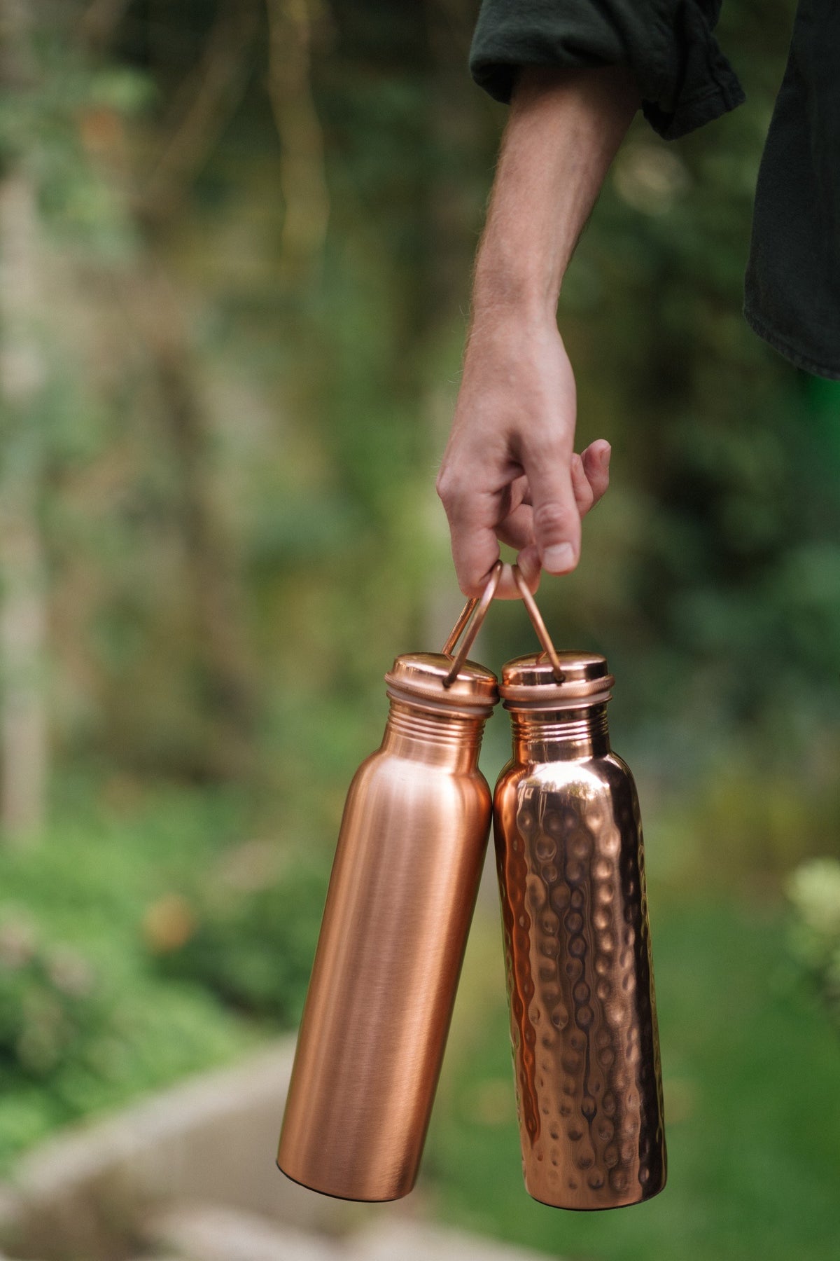 Kopero Copper Water Bottle, the smooth and the hammered bottle together by the handle in one hand