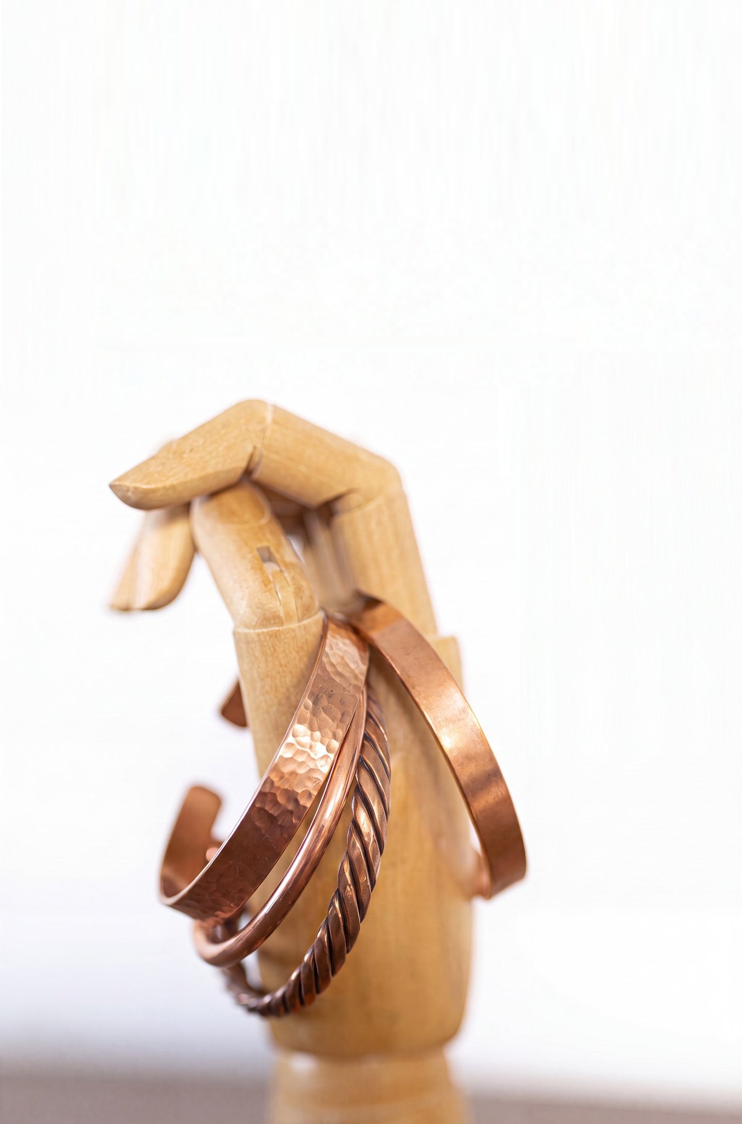 Kopero Copper Bracelet, all four versions side by side on a wooden jewelry hand