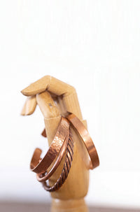 Kopero Copper Bracelet, all four versions side by side on a wooden jewelry hand