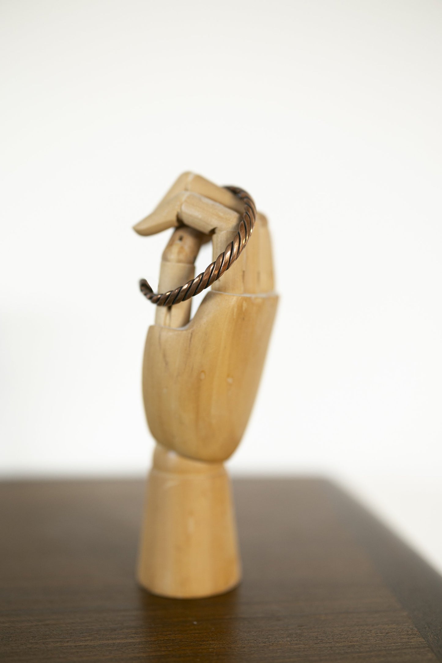Kopero Copper Bracelet Twisted on a wooden jewelry hand