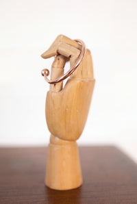 Kopero Copper Bracelet Round on a wooden jewelry hand