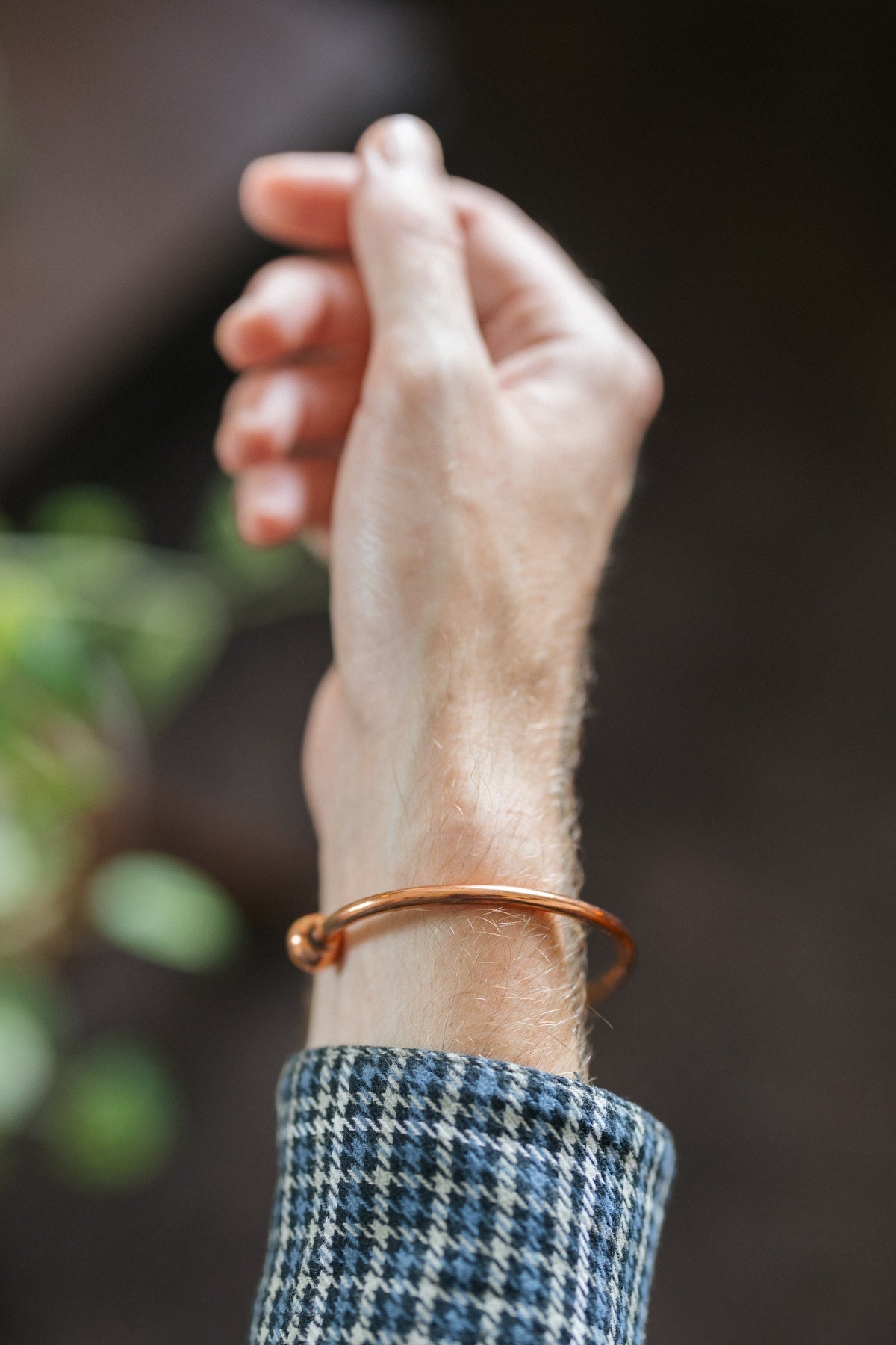 Kopero Copper Bracelet Round, on the wrist, with the hand raised against a dark background