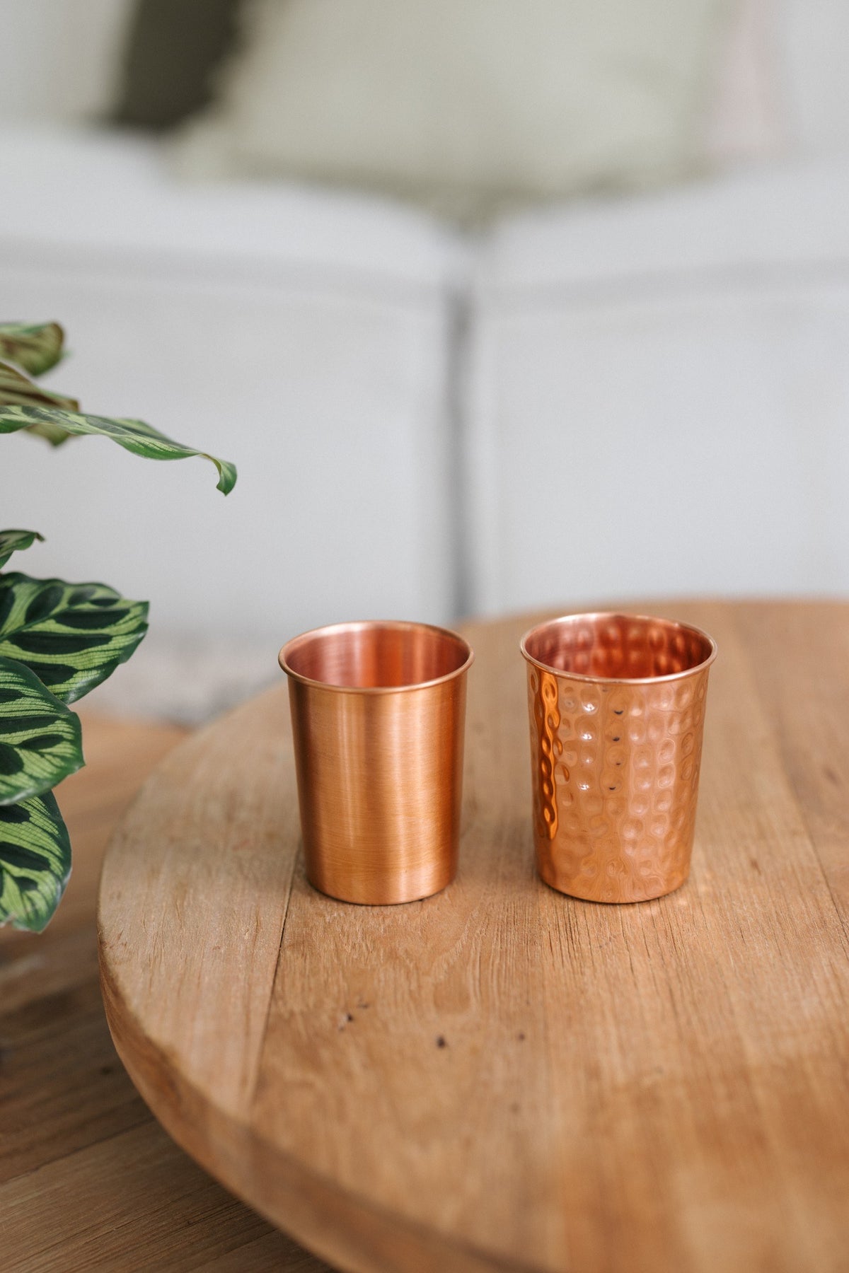 Kopero Copper Cup, a smooth and a hammered cup side by side on a round wooden table