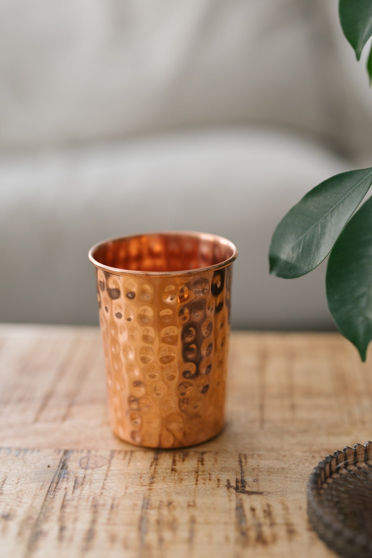 Kopero Copper Cup Hammered, on a wooden table in front of a sofa