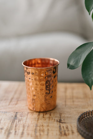 Kopero Copper Cup Hammered, on a wooden table in front of a sofa
