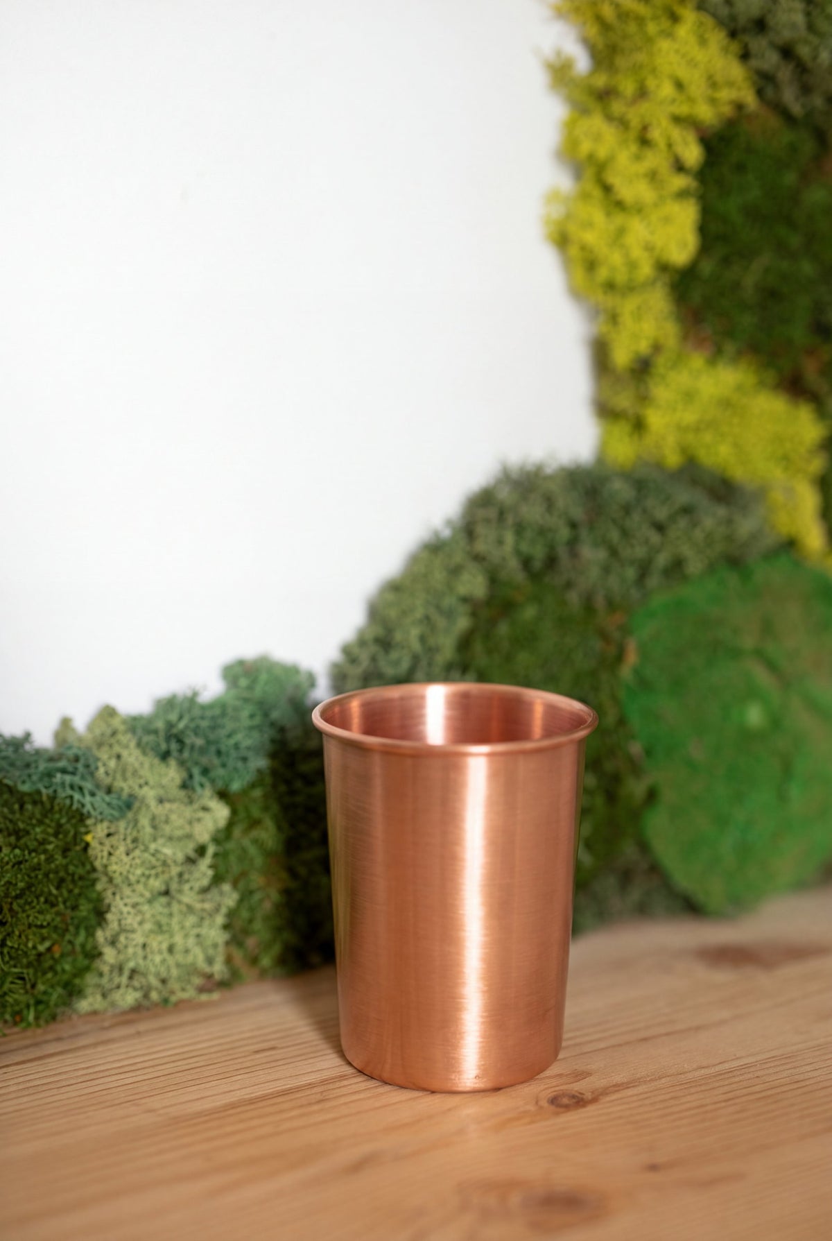 Kopero Copper Cup Smooth in front of a moss painting on a pine shelf