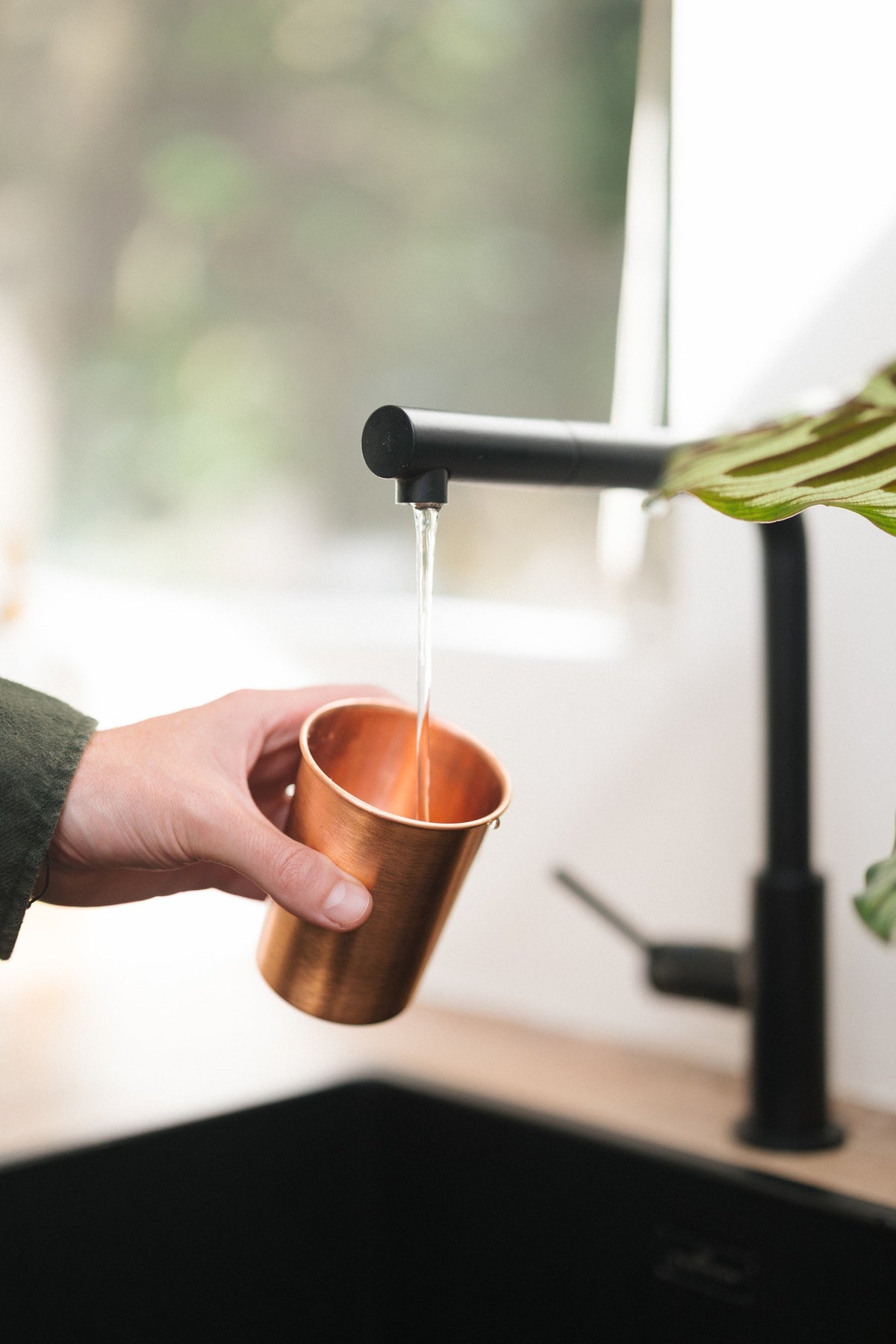 Kopero Copper Cup Smooth, being filled under the tap