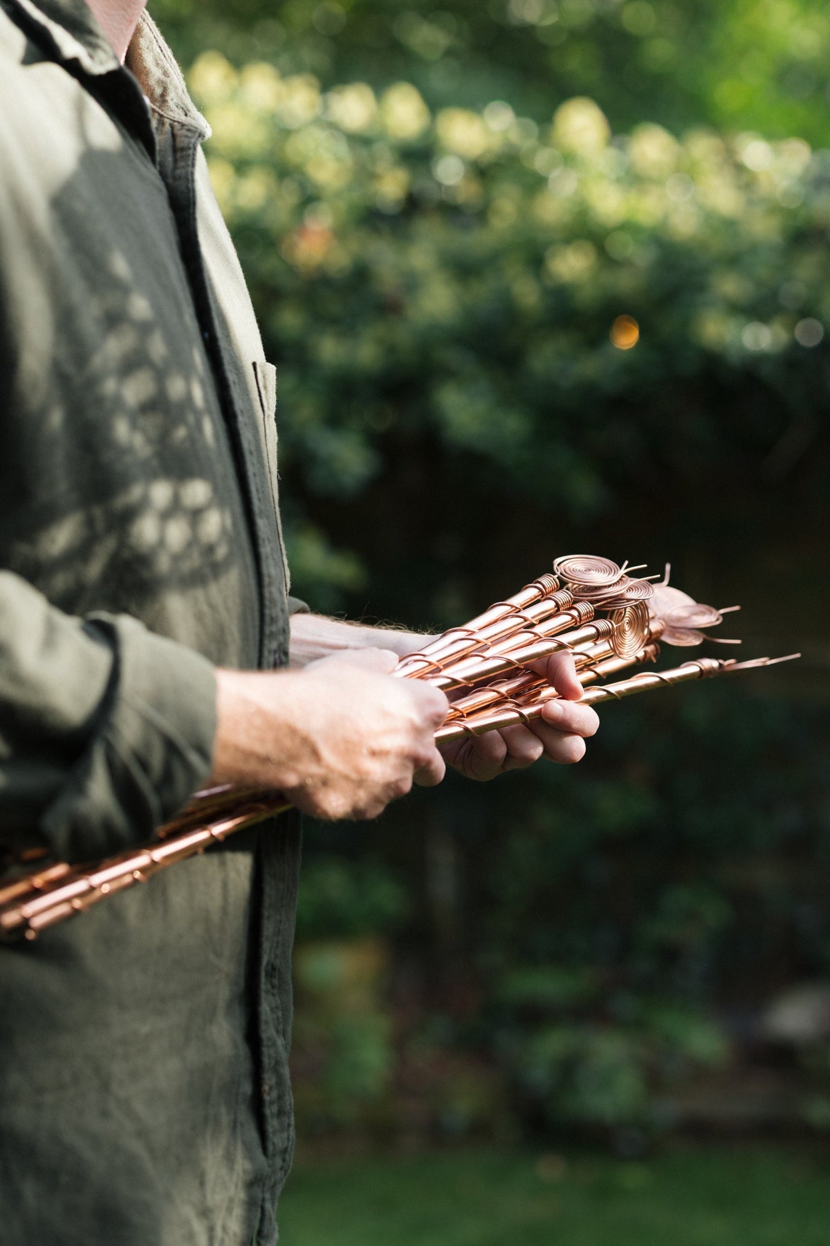 Kopero Electroculture, a bunch of copper antennas in two hands in the garden