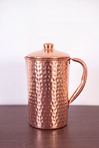 Kopero Copper Jug Hammered 1.4 liter with lid on a wooden table