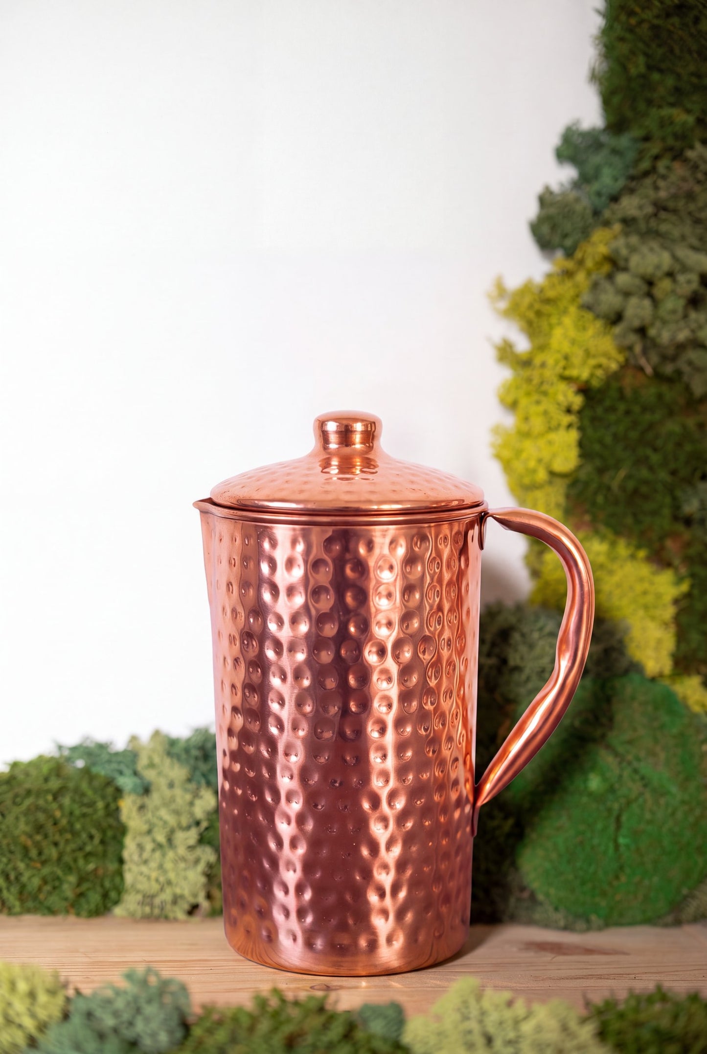 Kopero Copper Jug Hammered in front of a moss painting