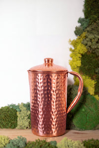 Kopero Copper Jug Hammered in front of a moss painting