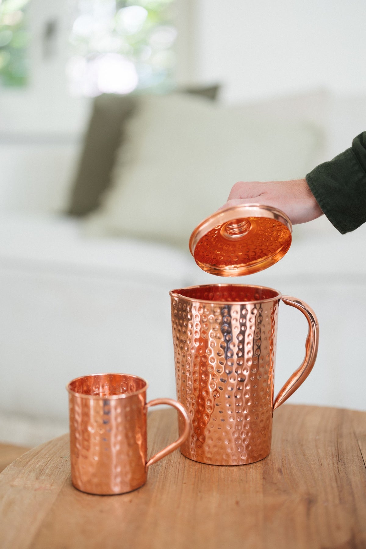 Kopero Copper Jug Hammered, while the lid is being lifted, with a mug next to it