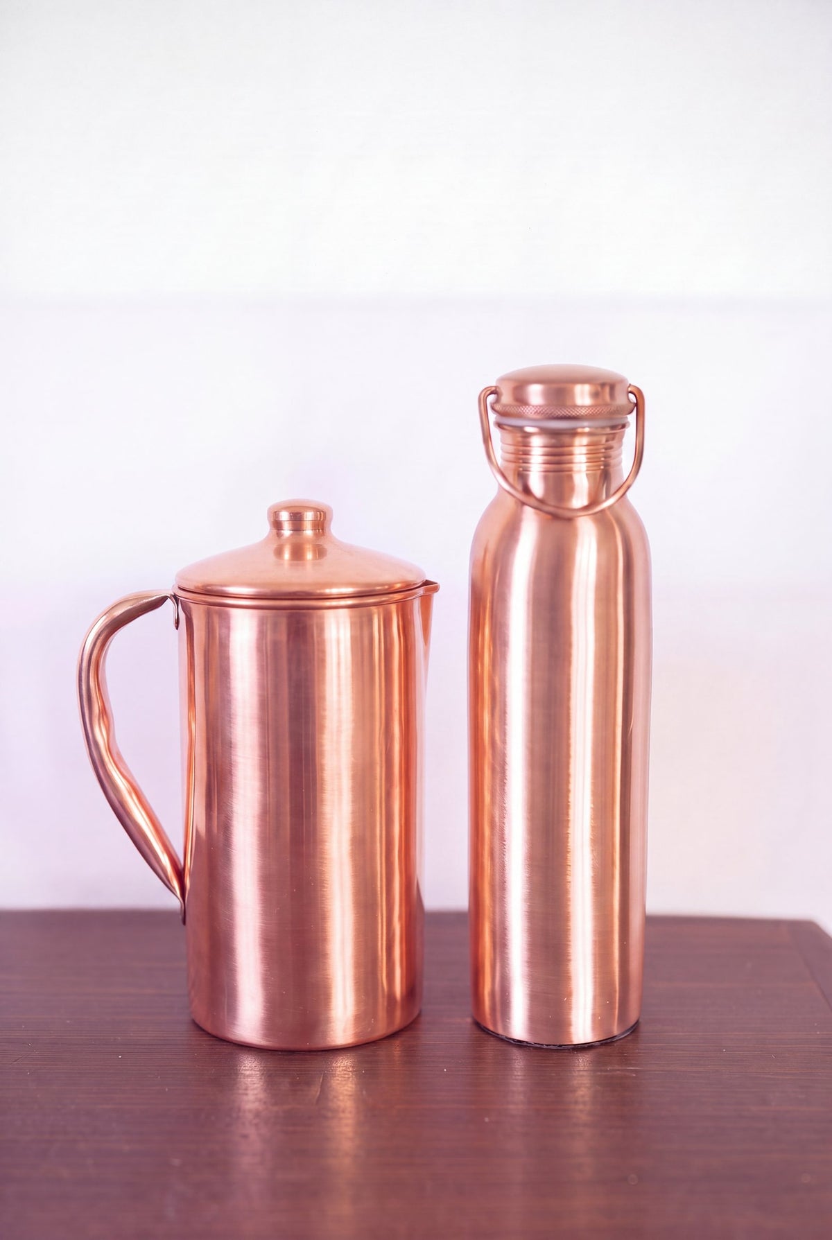 Kopero Copper Jug Smooth next to the copper water bottle from the Kopero collection