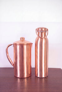 Kopero Copper Jug Smooth next to the copper water bottle from the Kopero collection