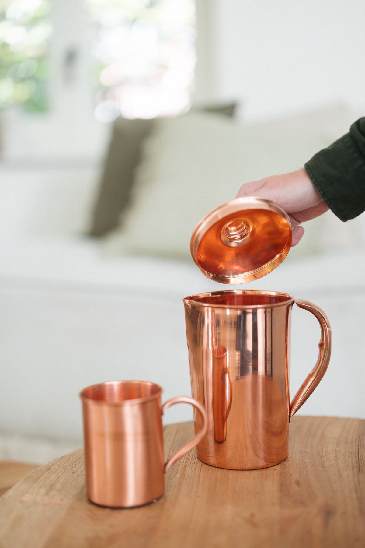 Kopero Copper Jug Smooth, while the lid is being lifted, with a mug next to it