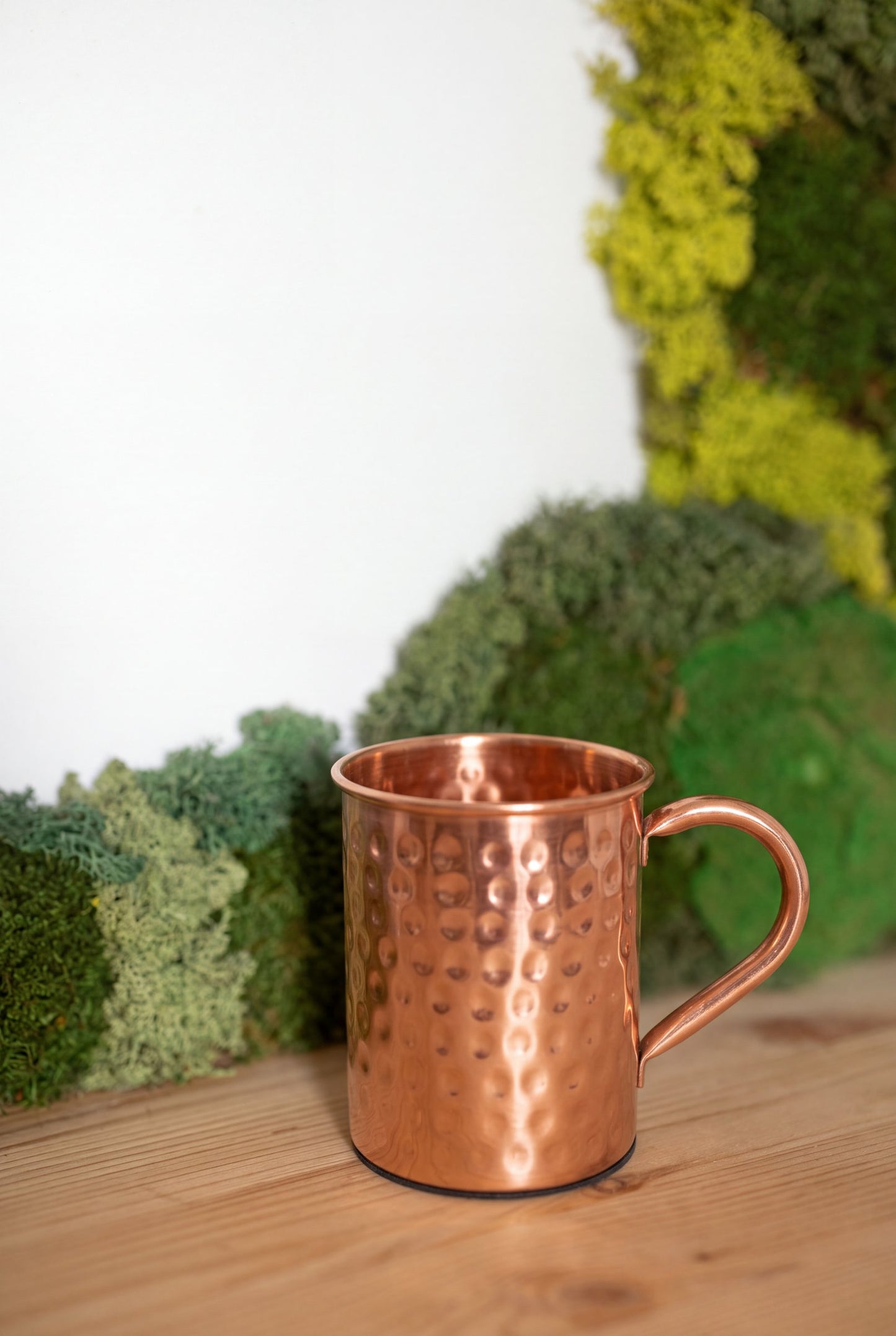 Kopero Copper Mug Hammered in front of a moss painting on a pine shelf