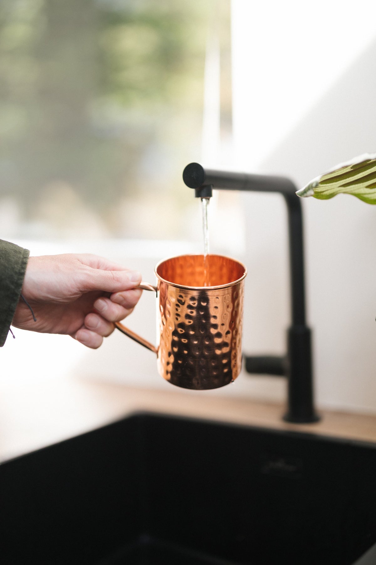 Kopero Copper Mug Hammered, in a hand under the tap