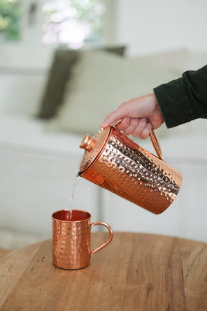 Kopero Copper Mug Hammered, while water is poured in from a copper jug