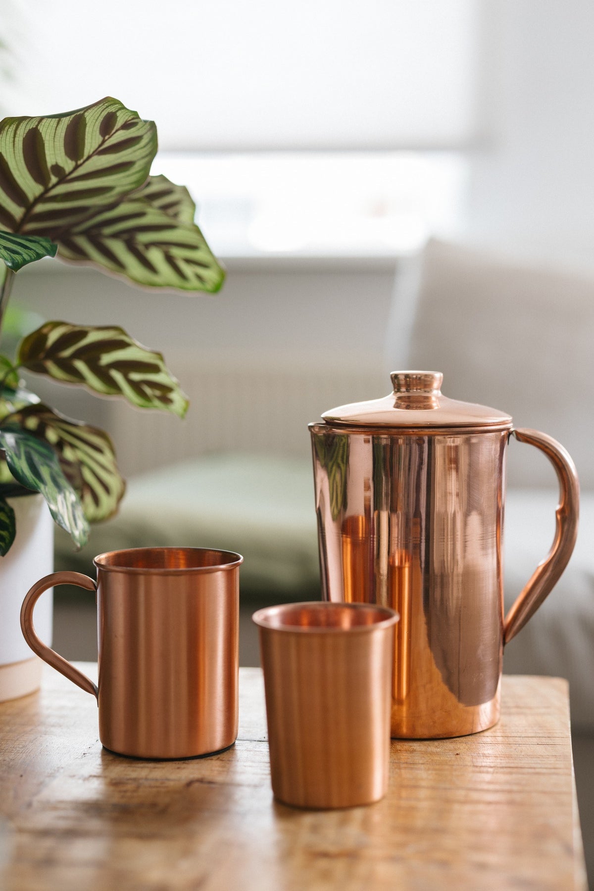 Kopero Copper Mug Smooth, next to a cup and a jug made of the same copper