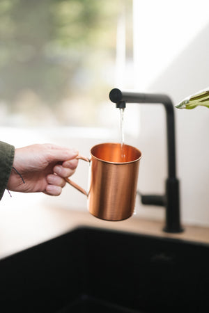 Kopero Copper Mug Smooth, in a hand under the tap