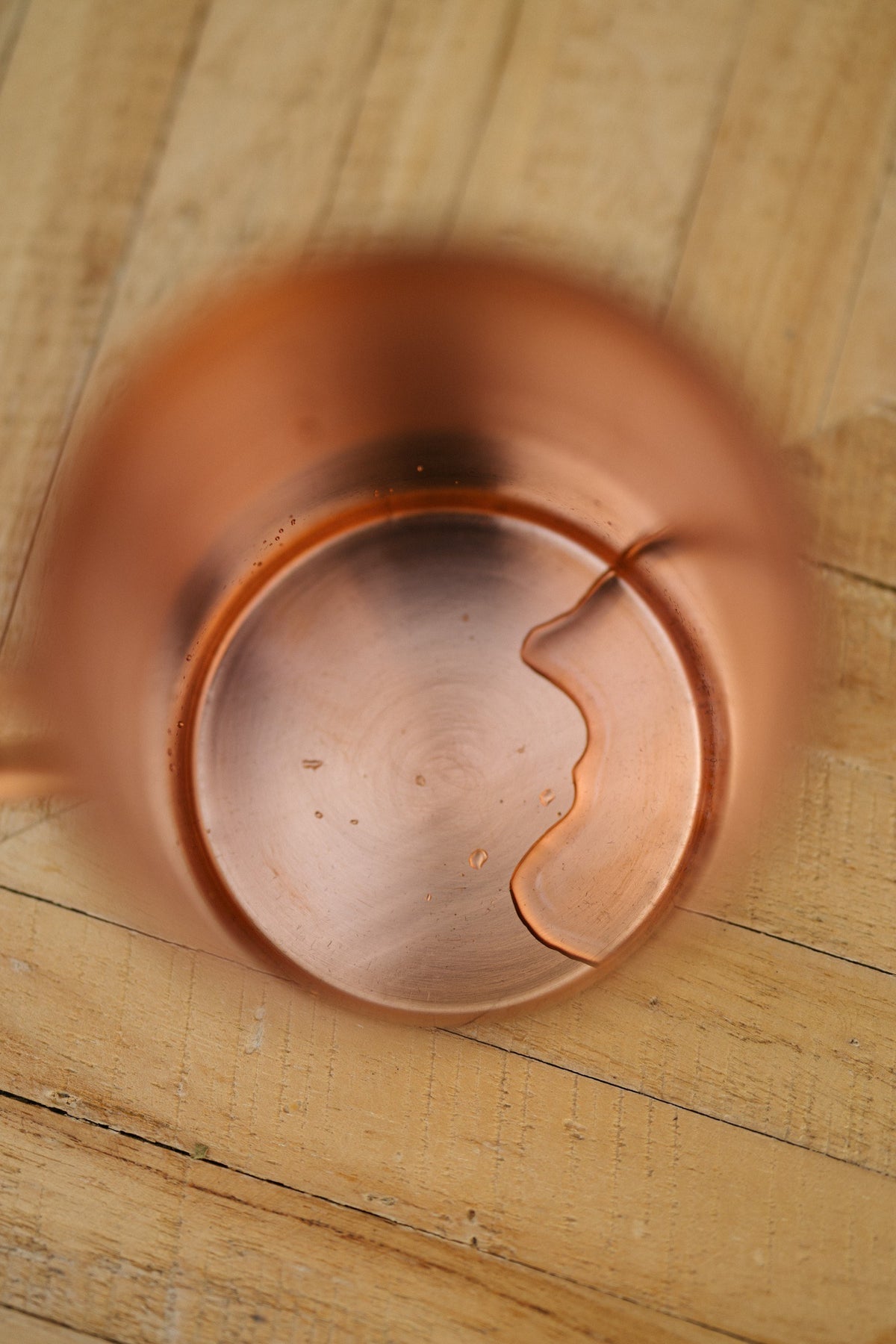 Kopero Copper Mug Smooth, seen from above: the inside of the mug on a wooden table