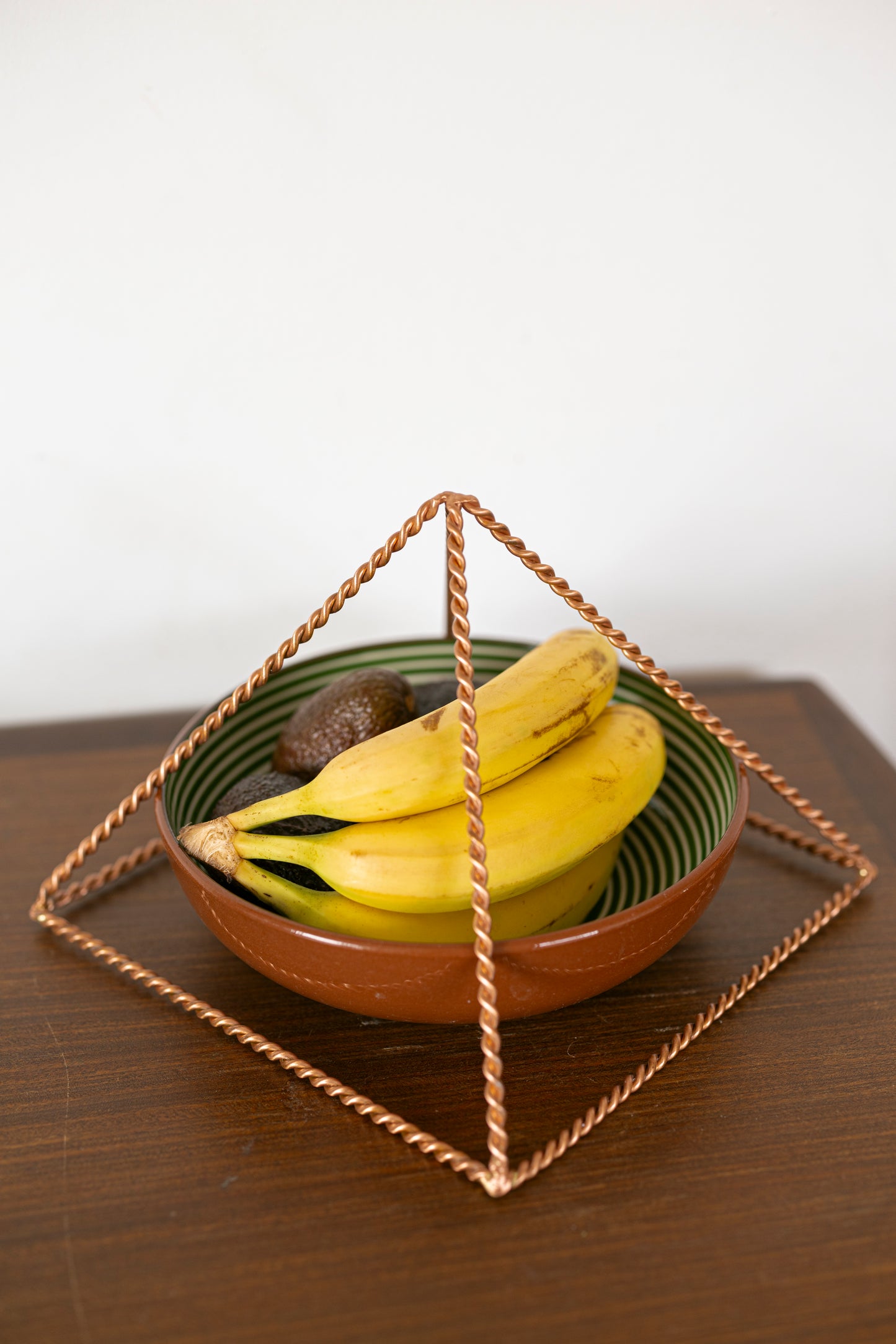 Kopero Koperen Piramide Energizer Gedraaid, 23,56 cm, schuine hoek boven een schaal fruit