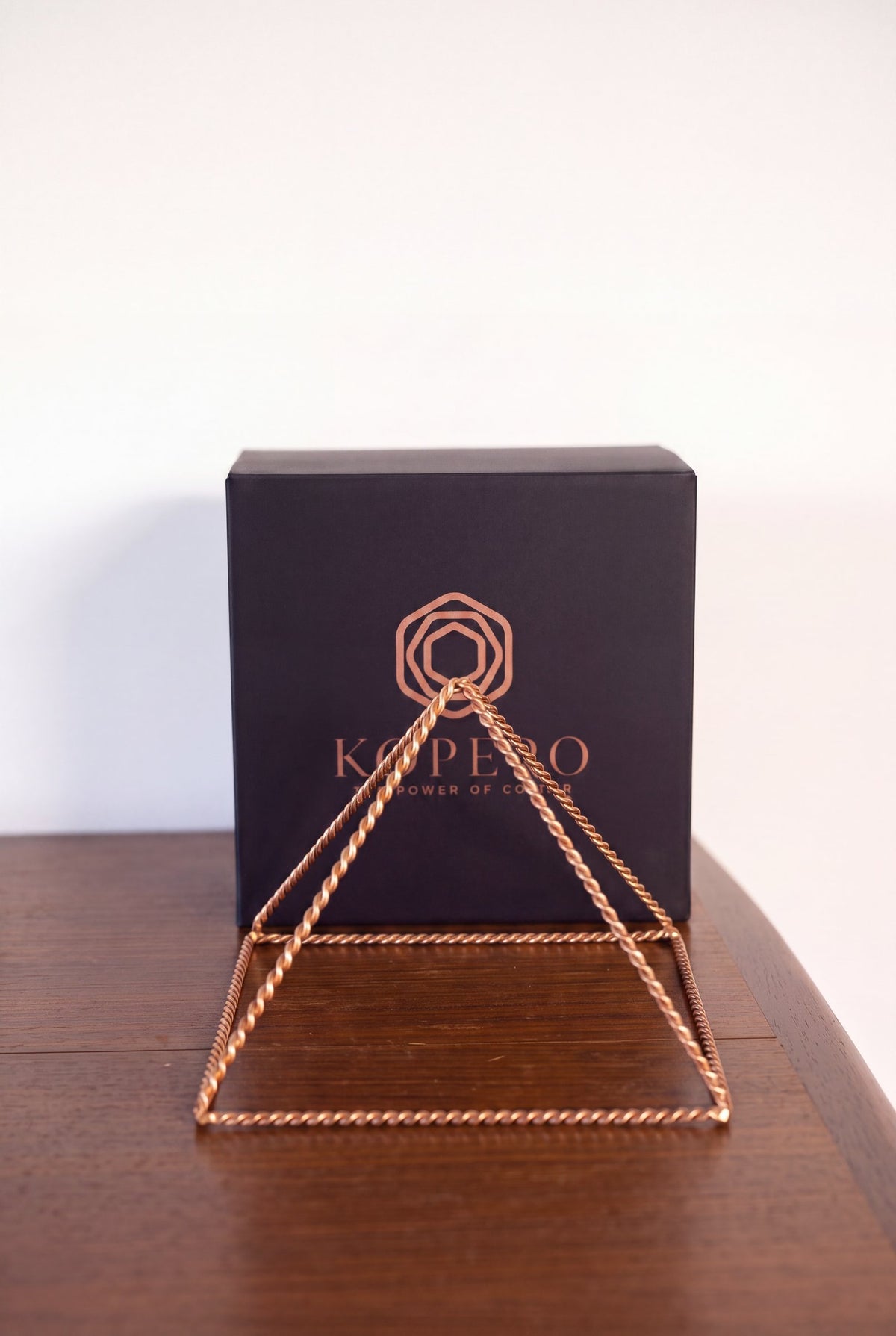 Kopero Copper Pyramid Energizer Twisted Large (23.56 cm) in front of the black Kopero gift box
