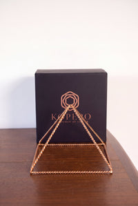 Kopero Copper Pyramid Energizer Twisted Large (23.56 cm) in front of the black Kopero gift box