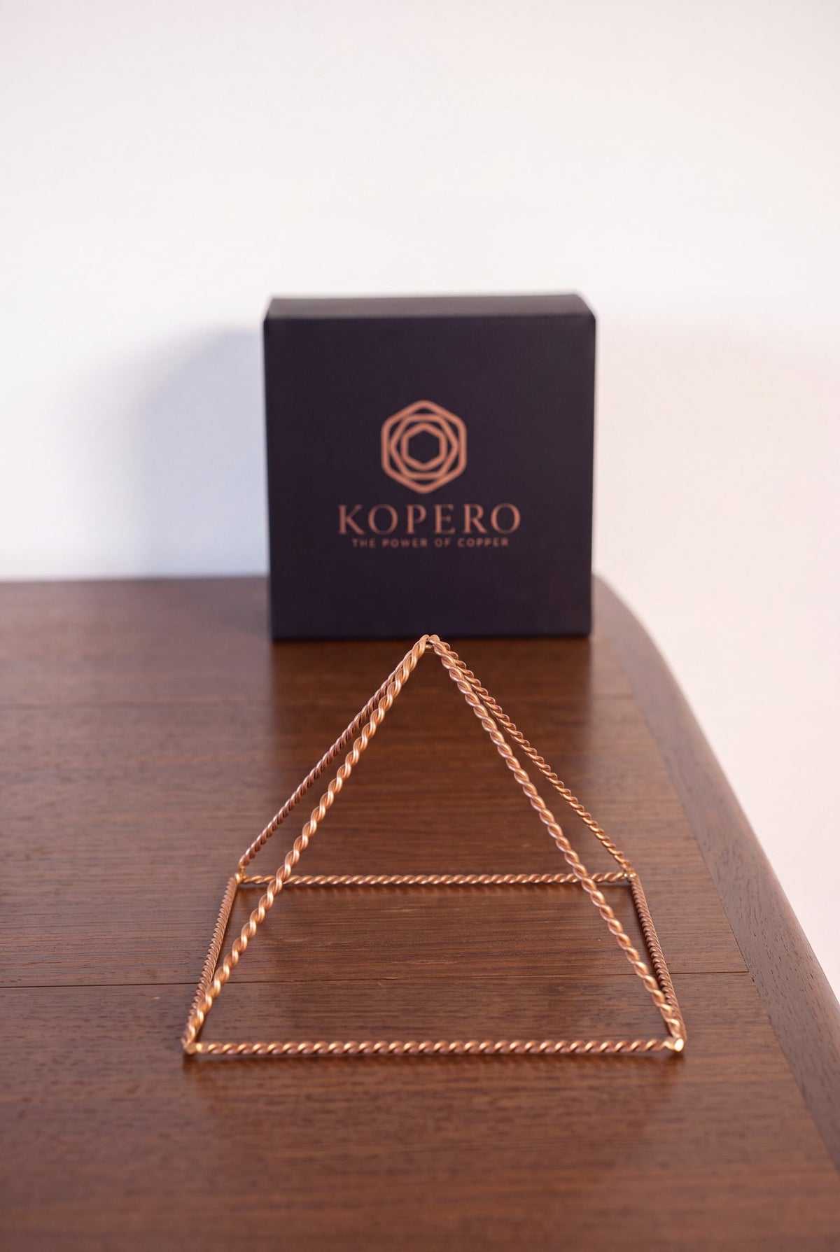 Kopero Copper Pyramid Energizer Twisted Small (14.56 cm) in front of the black Kopero gift box