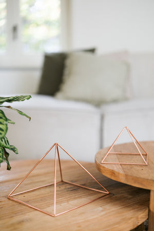 Kopero Copper Pyramid Energizer Smooth, the small and the large pyramid side by side on two wooden tables