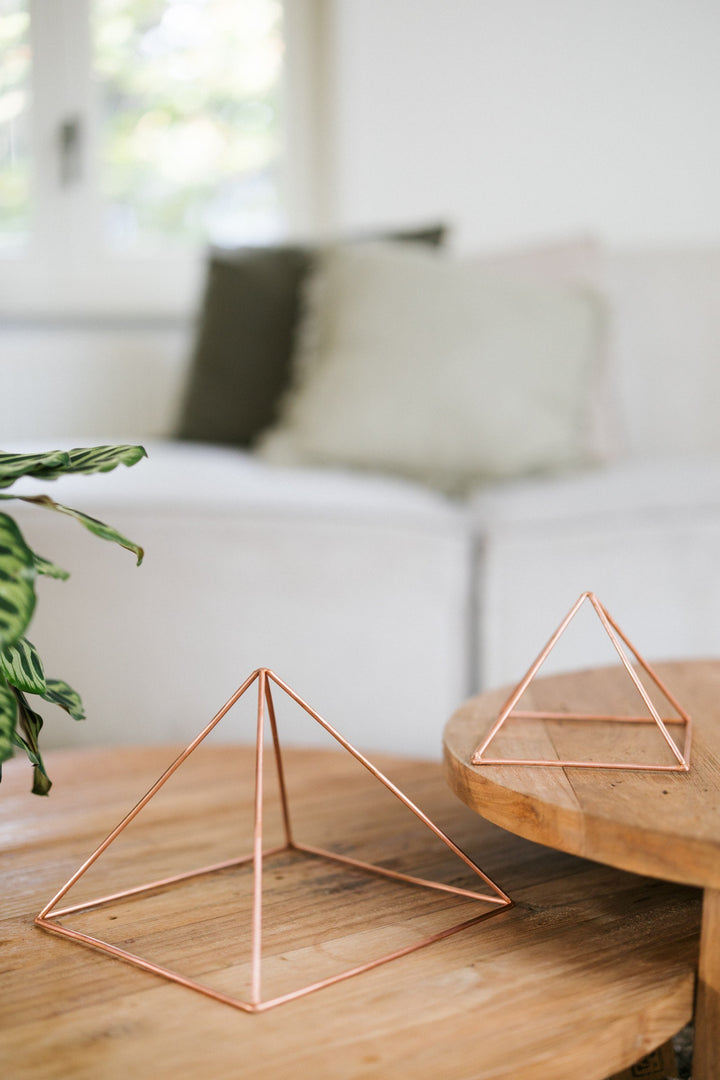 Kopero Copper Pyramid Energizer Smooth, the small and the large pyramid side by side on two wooden tables