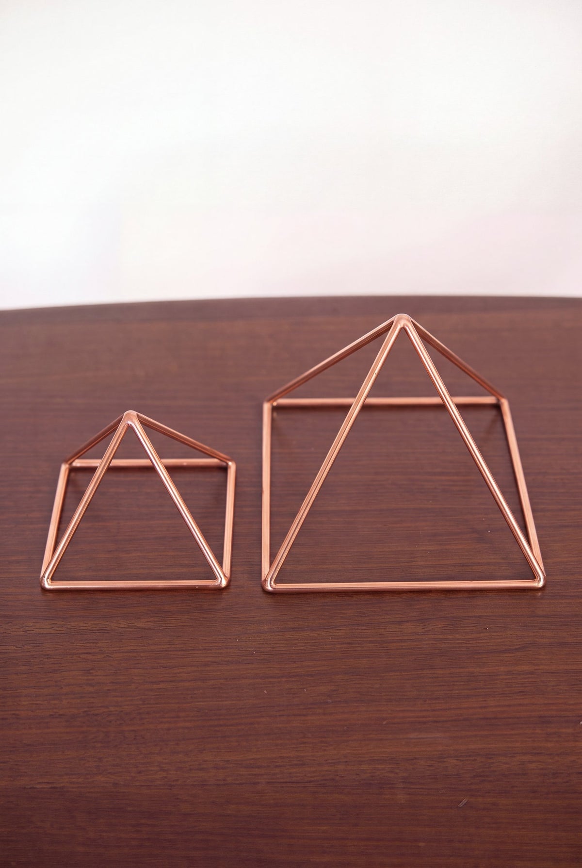 Kopero Copper Pyramid Energizer Smooth, both sizes side by side on a wooden table