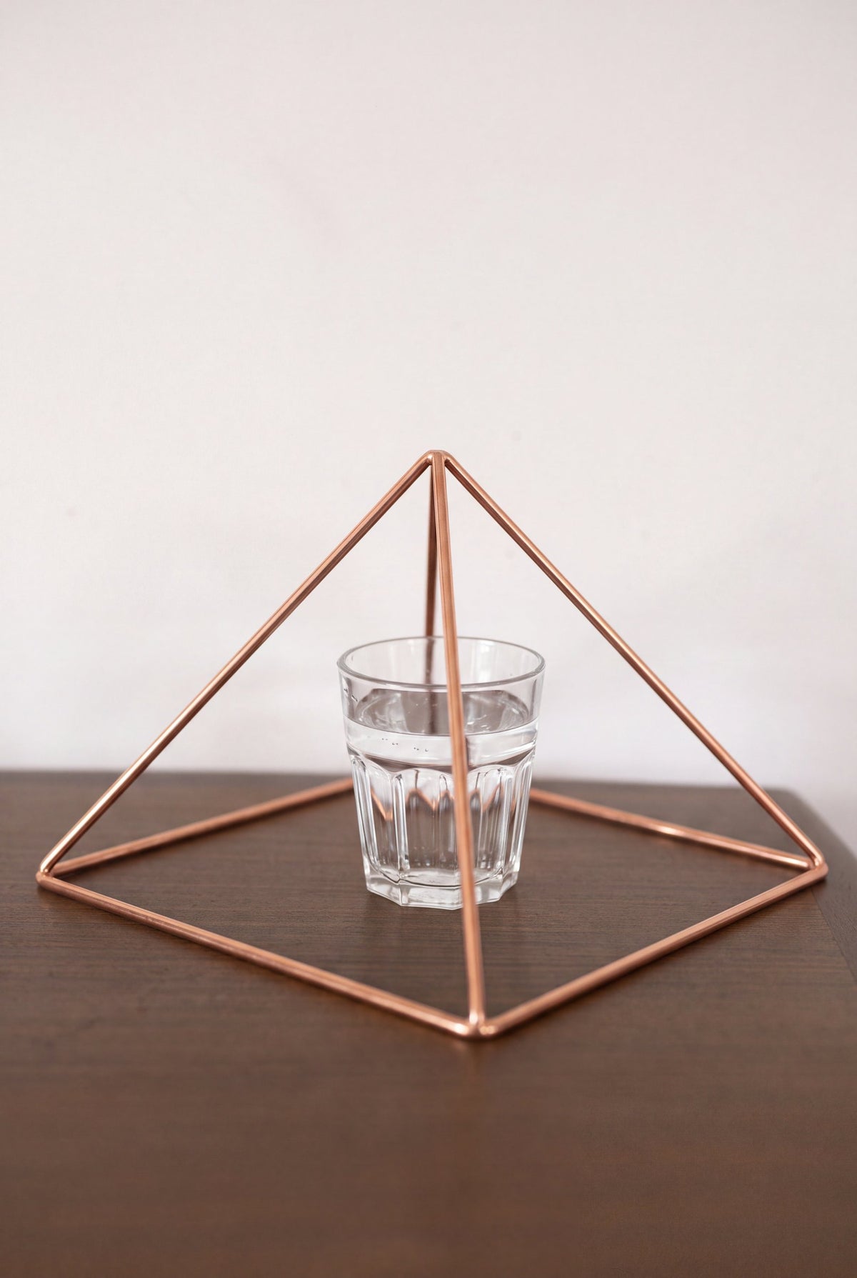 Kopero Copper Pyramid Energizer Smooth Large (23.56 cm) above a glass of water