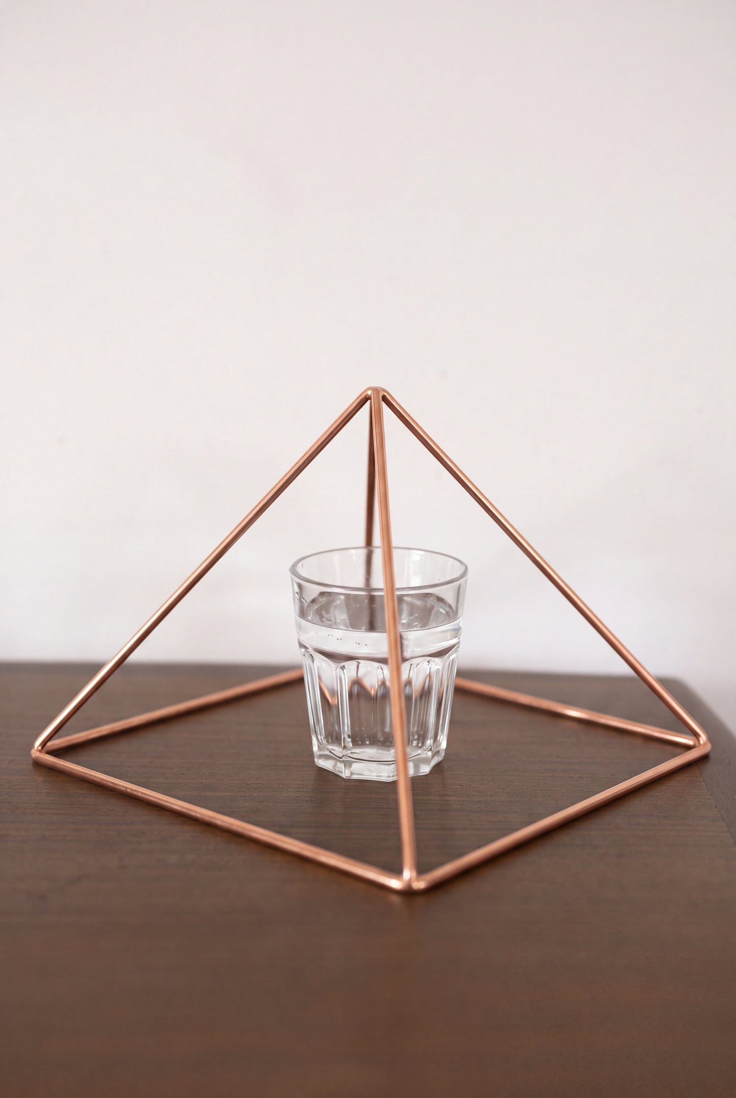 Kopero Copper Pyramid Energizer Smooth Large (23.56 cm) above a glass of water