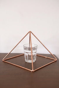 Kopero Copper Pyramid Energizer Smooth Large (23.56 cm) above a glass of water