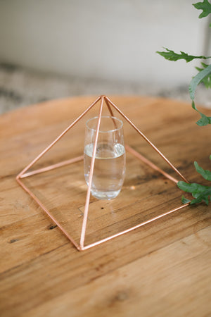 Kopero Copper Pyramid Energizer Smooth Large (23.56 cm), with a glass of water underneath