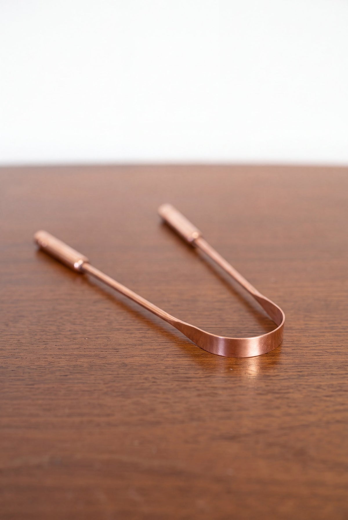 Kopero Copper Tongue Scraper made of pure copper on a wooden table
