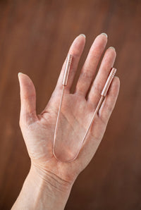 Kopero Copper Tongue Scraper in a palm, for size indication