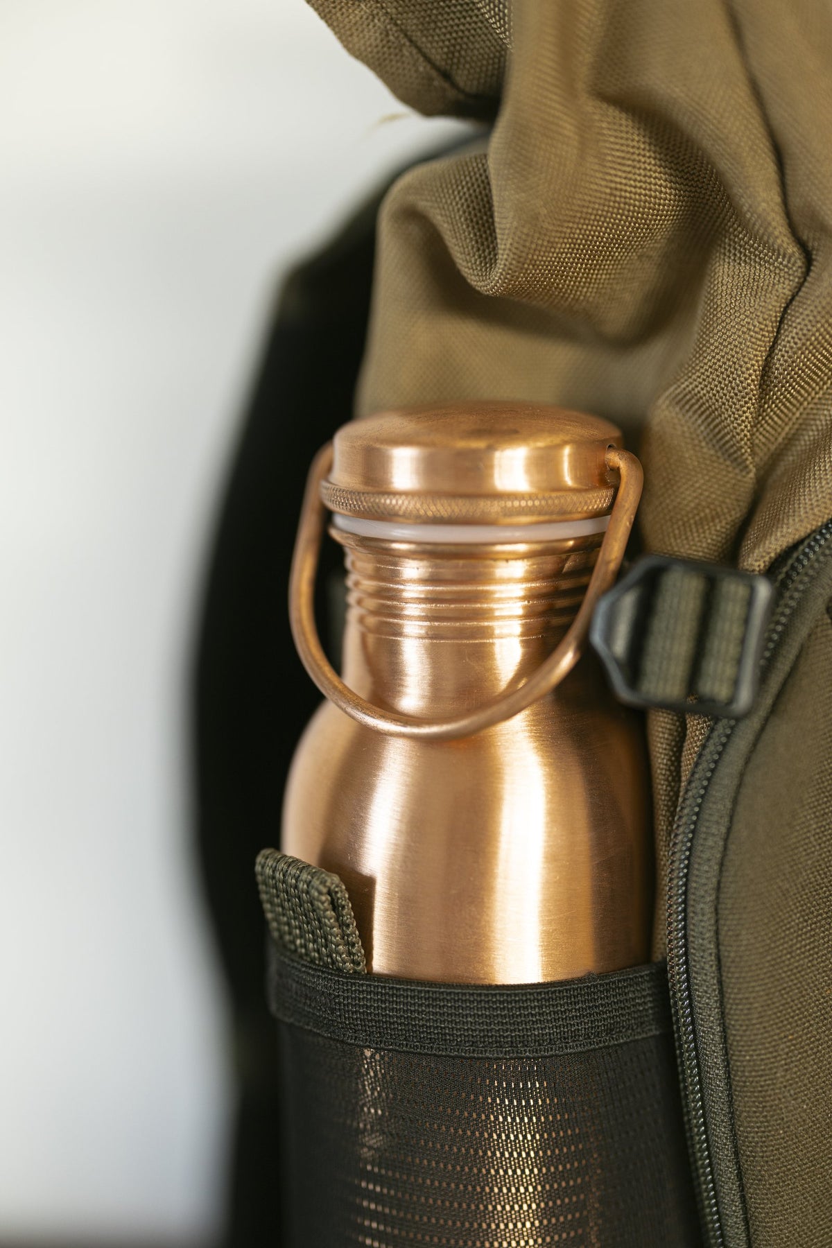 Kopero Copper Water Bottle Smooth in the bottle pocket of a backpack