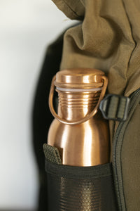 Kopero Copper Water Bottle Smooth in the bottle pocket of a backpack